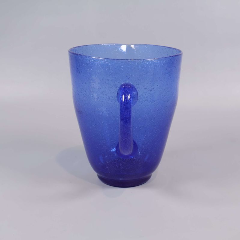 Blå kanna i glas sedd rakt bakifrån, handtag tydligt synligt