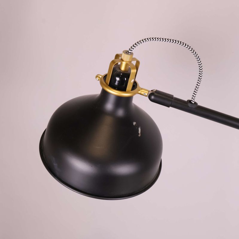 Svart lampskärm i metall med mässingsdetaljer i närbild