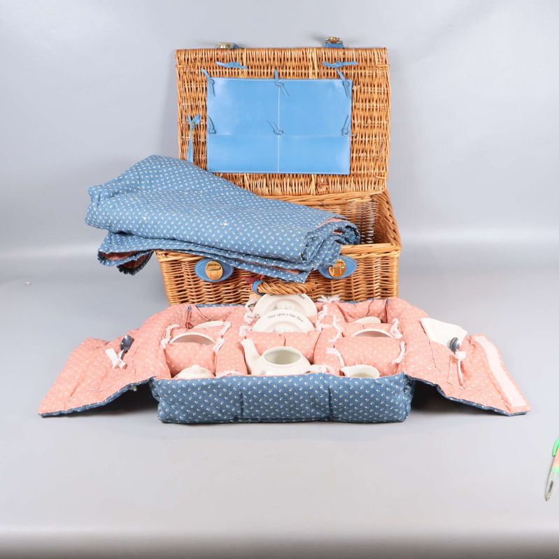 Öppen picnickorg med blått fodral och prickigt tyg