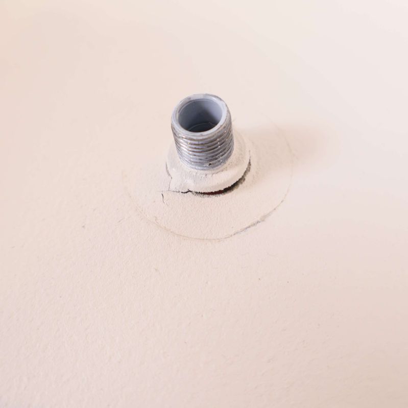 Närbild på lampans infästning med gängad metall