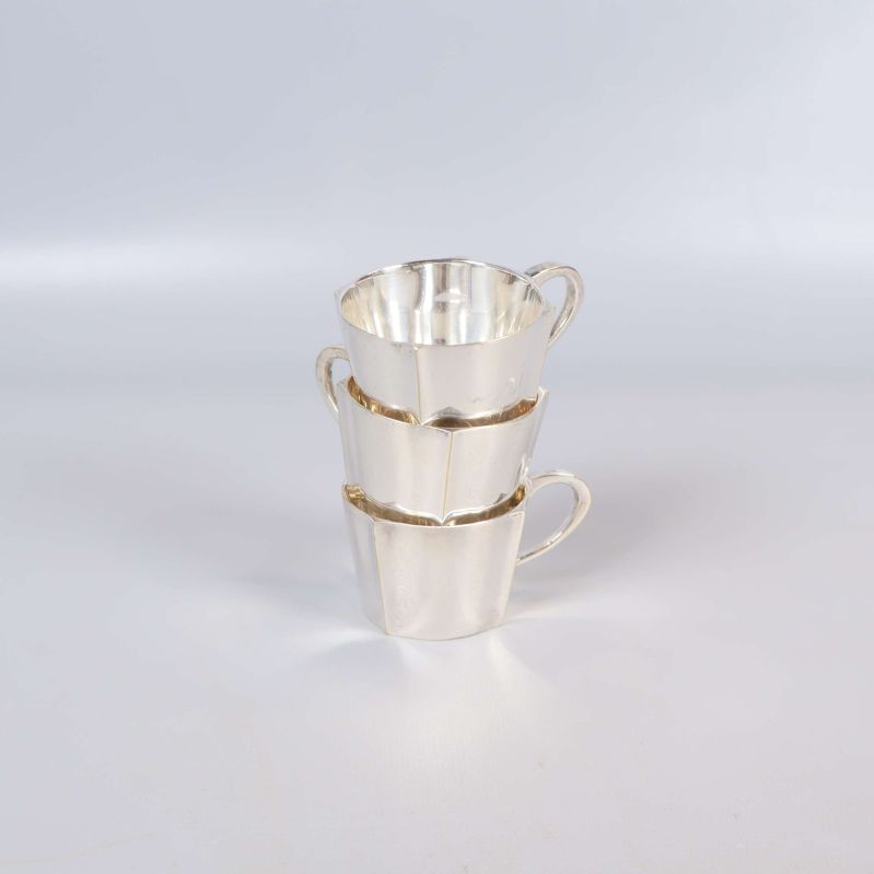 Tre staplade kaffekoppar i blankt nysilver
