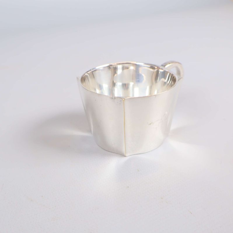 Närbild på en kaffekopp i nysilver och handtag