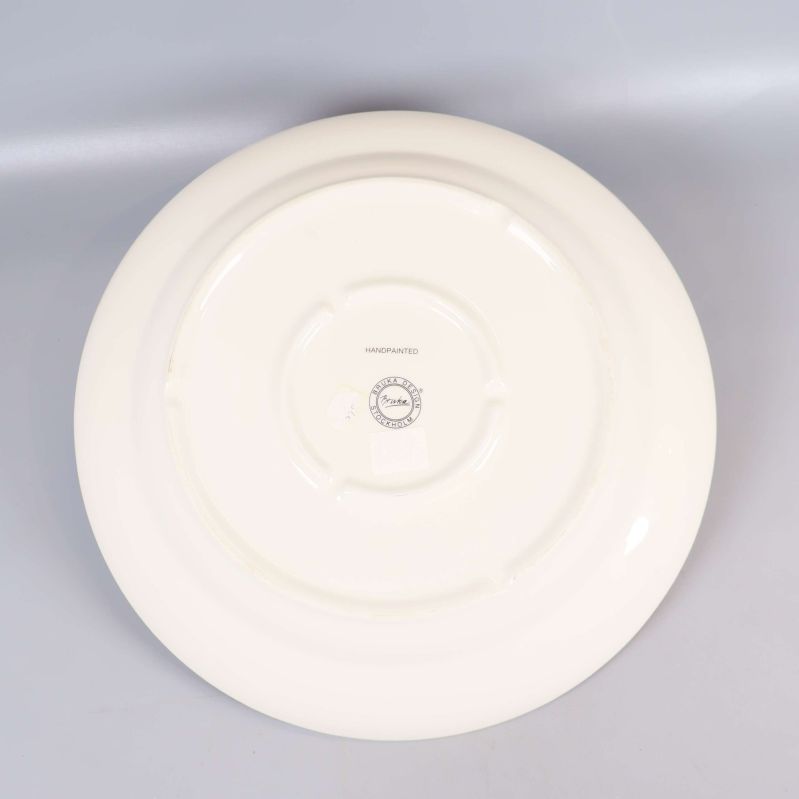 Tallrikens undersida med vit finish och stämpel