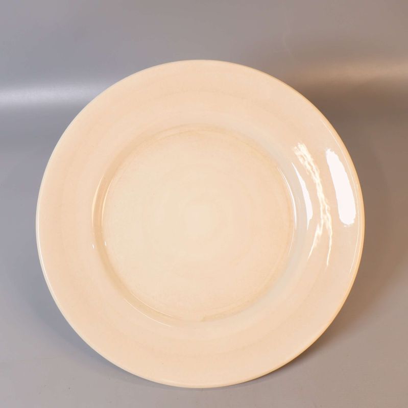 Stor rund beige mattallrik fotad uppifrån