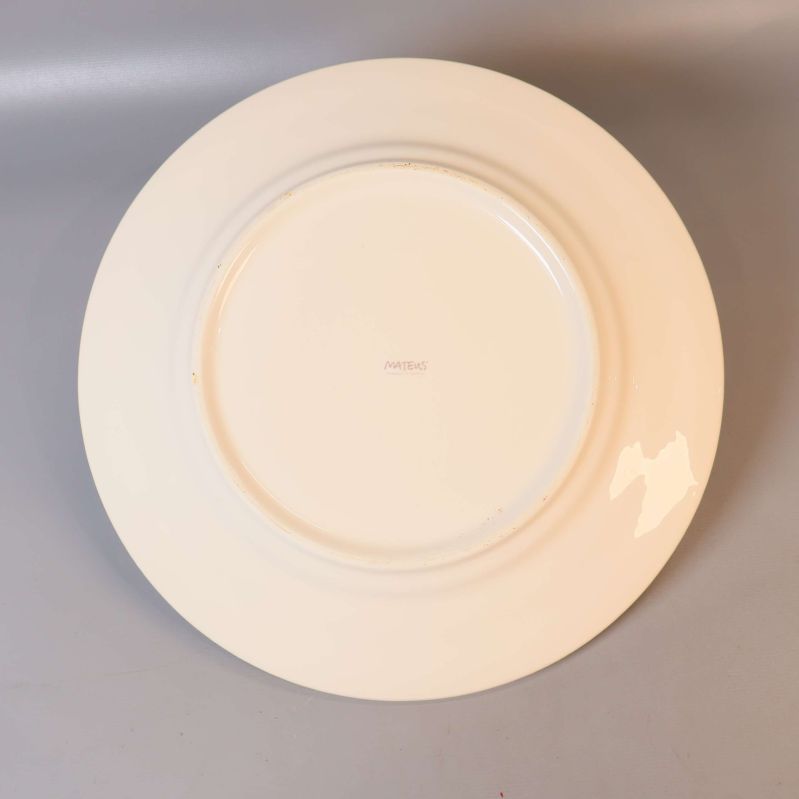 Baksidan av beige mattallrik med logga i mitten