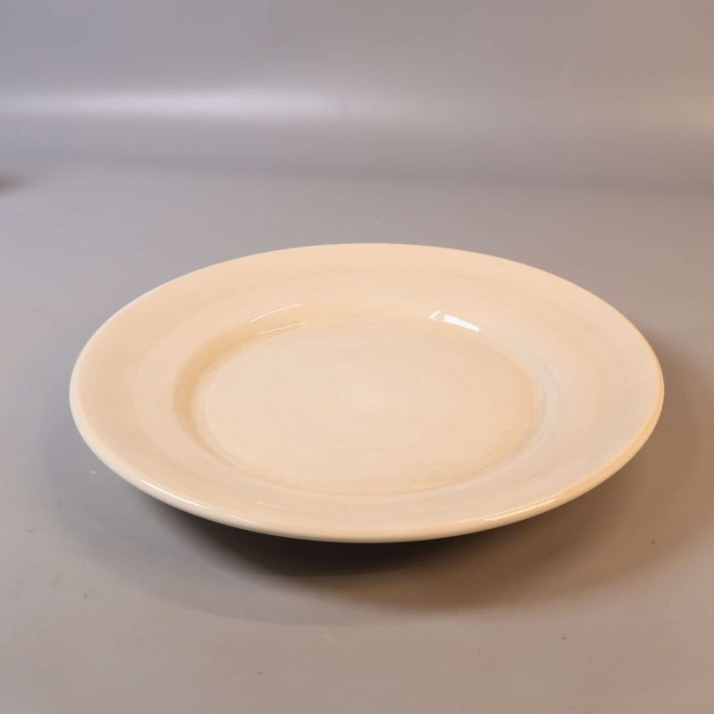 Beige mattallrik fotad i lätt vinkel
