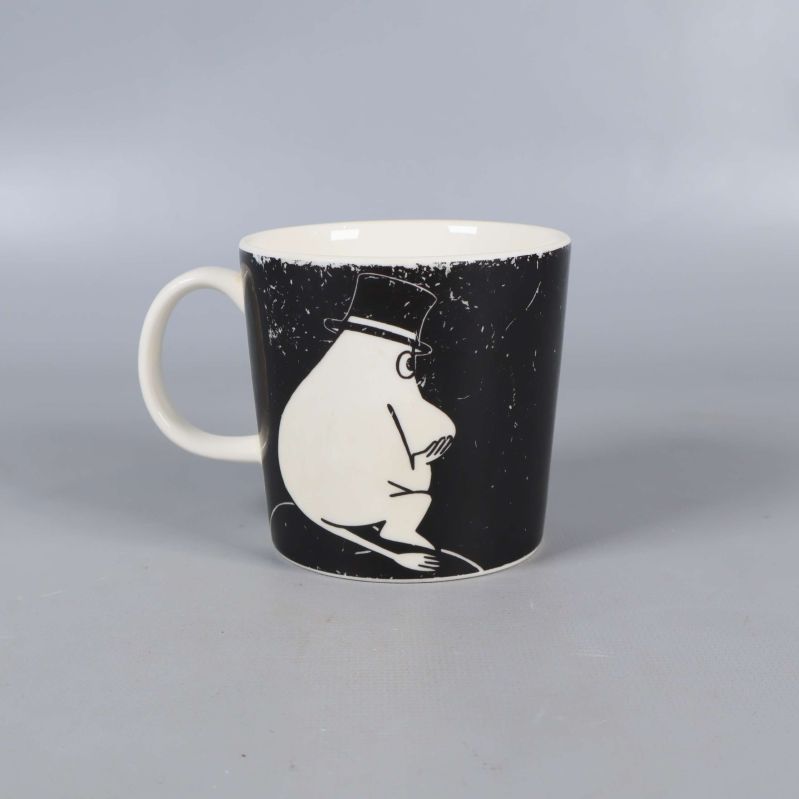 Mugg med muminpappa i hatt på svart bakgrund