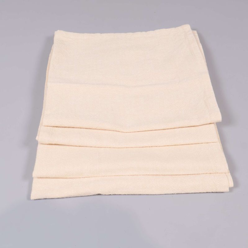 Tre vikta beige tygservetter staplade tillsammans