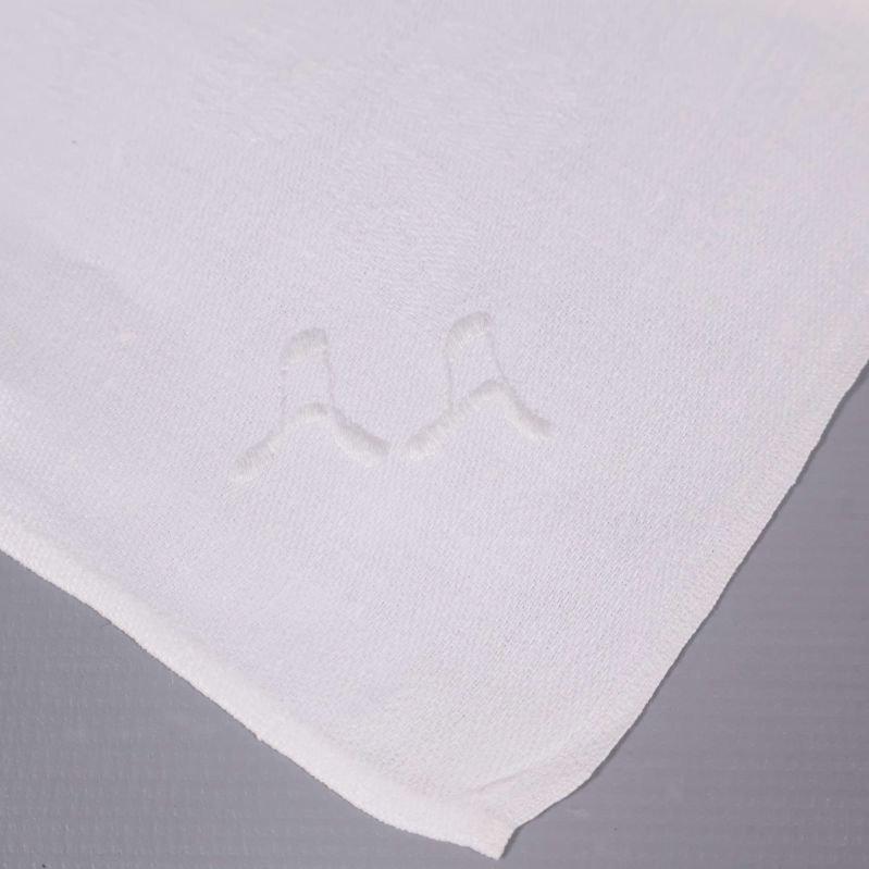 Närbild på broderat monogram AA i hörnet på servett