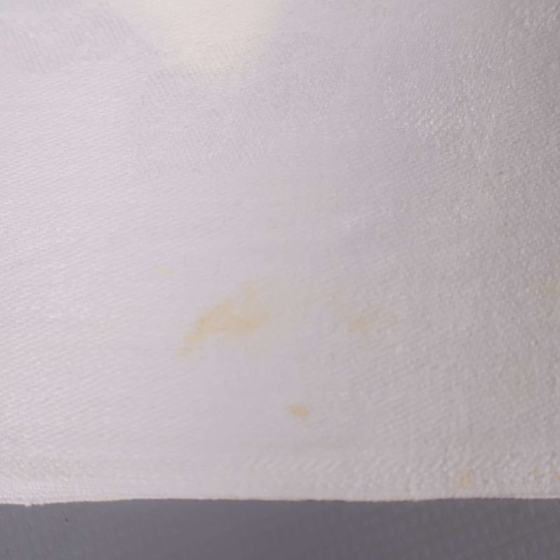Vit servett med mindre gulaktig fläck närbild