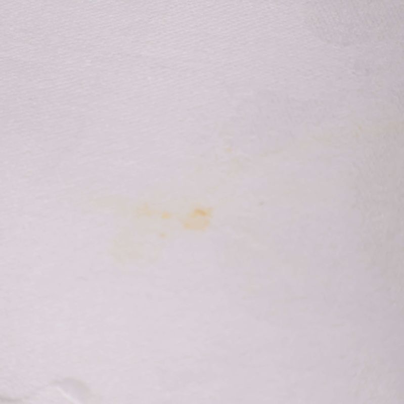 Detaljbild av mindre missfärgning på servett