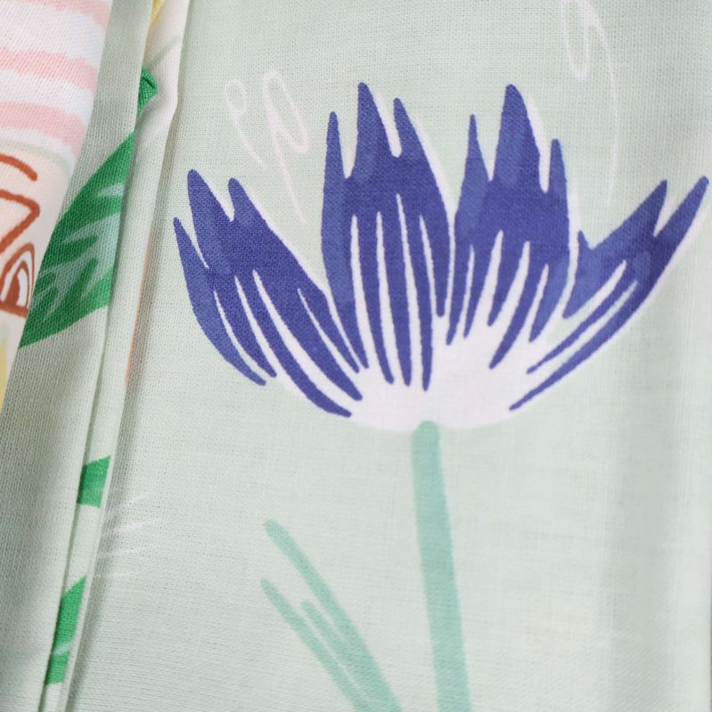 Närbild av örngott med blå blomma och gröna blad