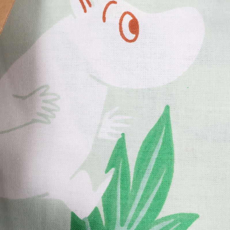Närbild av Muminfigur på ljusgrönt örngott