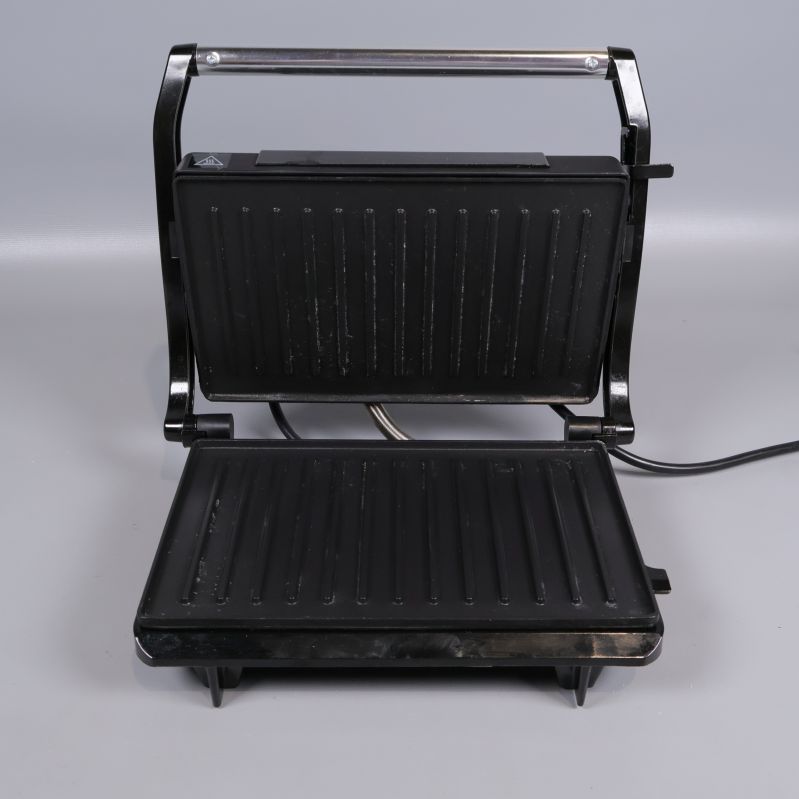 Paninigrillen öppen med synliga grillplattor