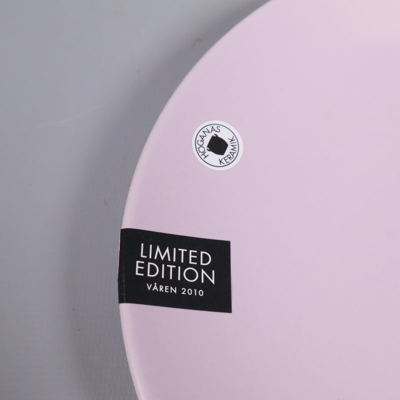 Närbild på limited edition-märke och logotyp på assiett