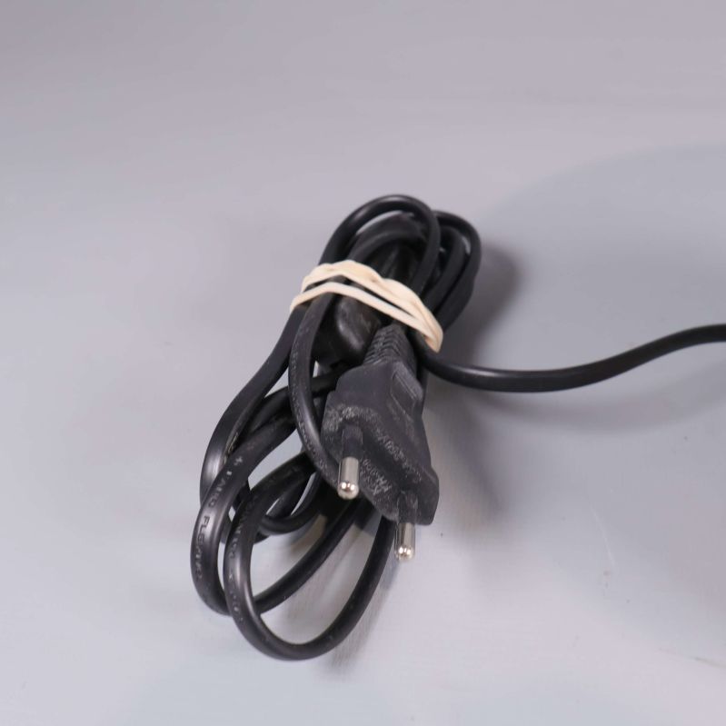 Svart elsladd till bordslampan ihopbunden med gummiband