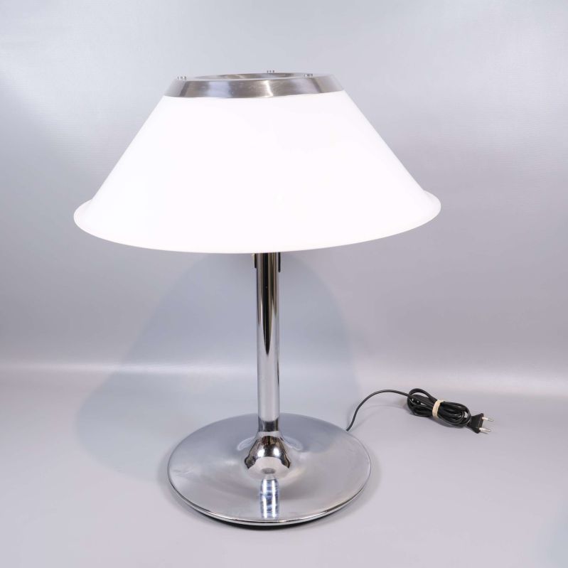 Vit bordslampa med rund metallfot sedd framifrån