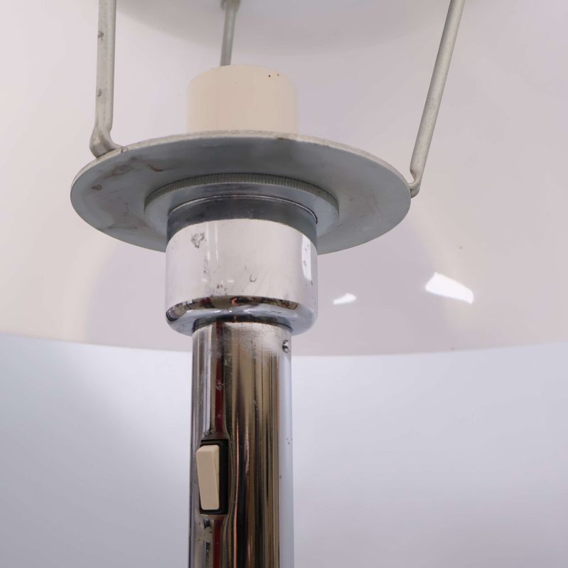Närbild under lampskärmen på strömbrytare och metalldetaljer
