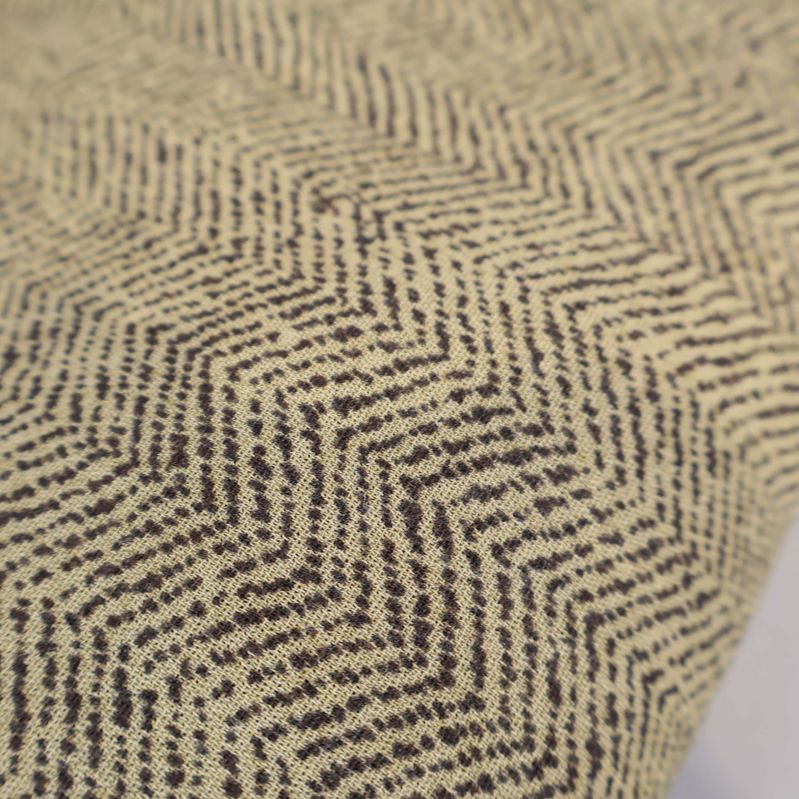 Närbild av tyg med zigzagmönster i beige och brunt