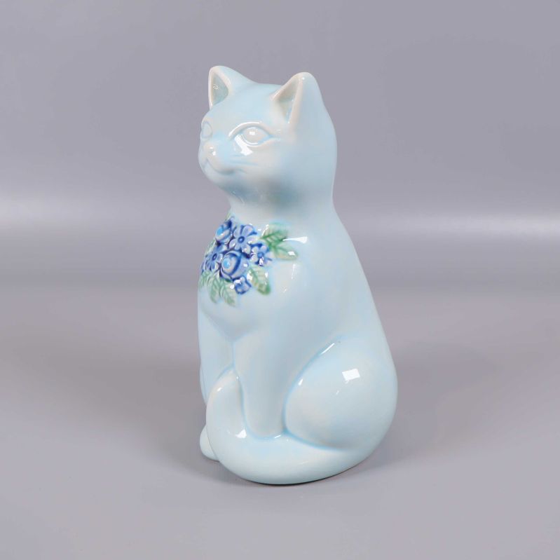 Kattfigur i ljusblå keramik sedd från sidan