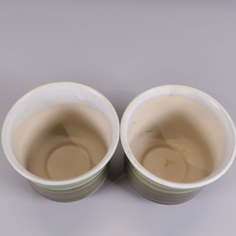 Insidan av båda koppar med ljust beige glasyr