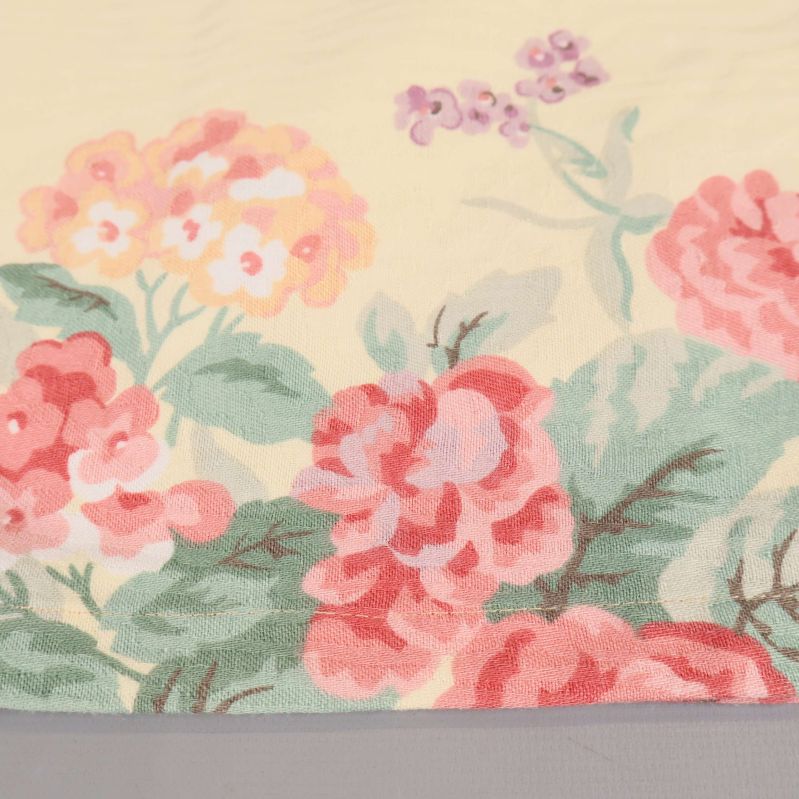 Närbild på blommigt tyg i mjuka färger