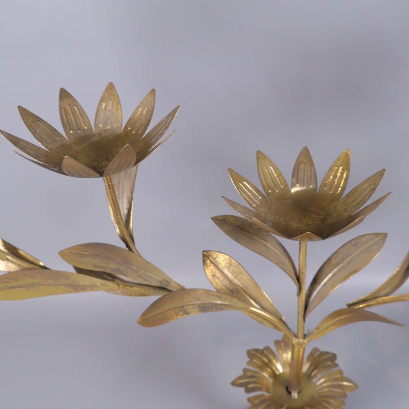 Närbild på två blomformade ljushållare med blad