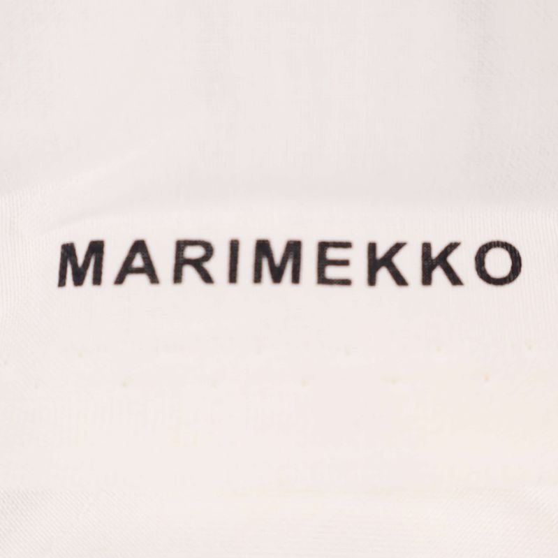 Närbild på MARIMEKKO logotyp tryckt på tyg