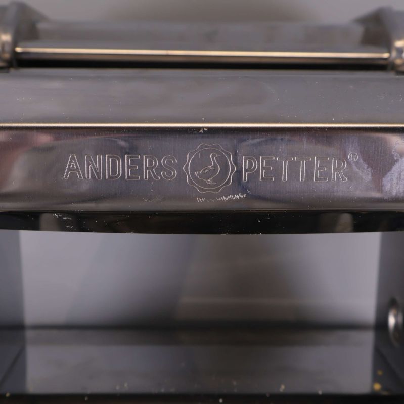 Närbild på Anders Petter-logotyp på metallhöljet