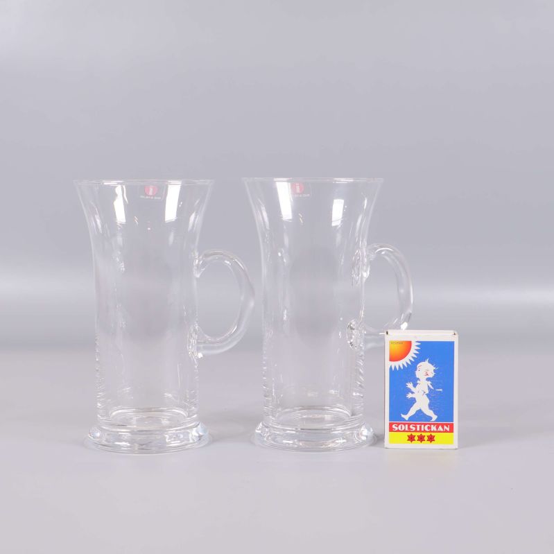 Två glas med handtag bredvid tändsticksask