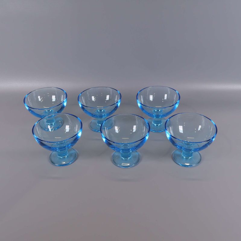Sex blå dessertskålar i glas på rad