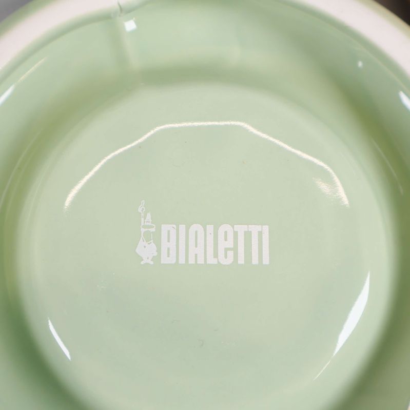 Närbild på grön kopp med Bialetti-logga på undersidan