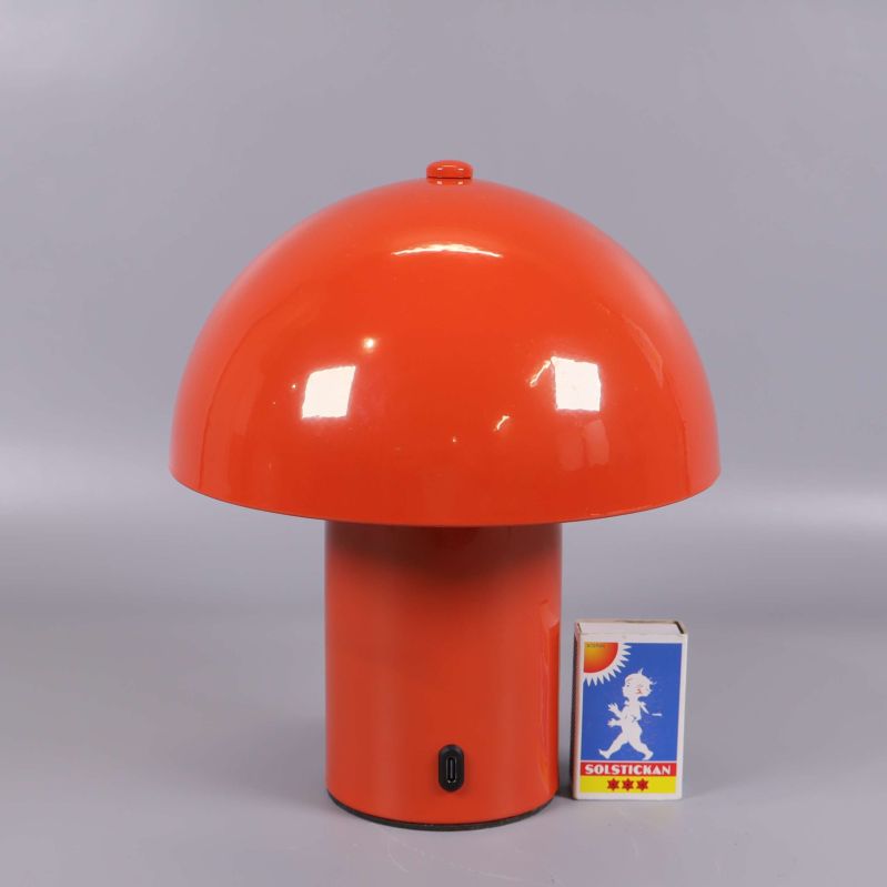 Orange bordslampa placerad bredvid tändsticksask för storleksjämförelse