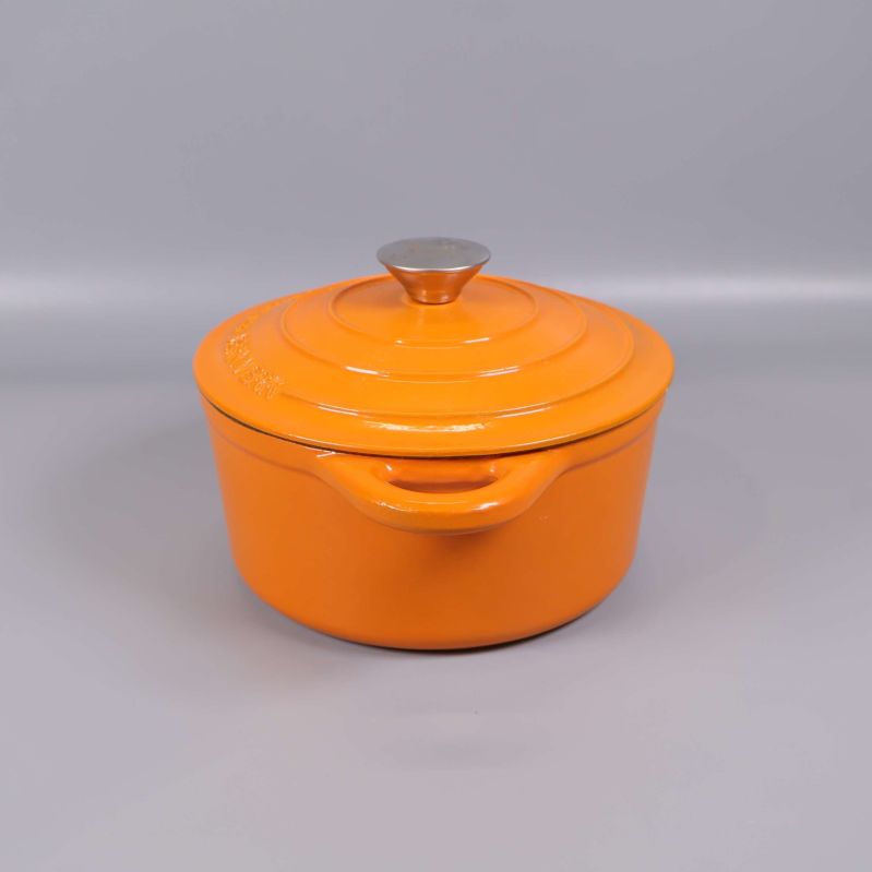 Orange gryta med lock, sedd från sidan