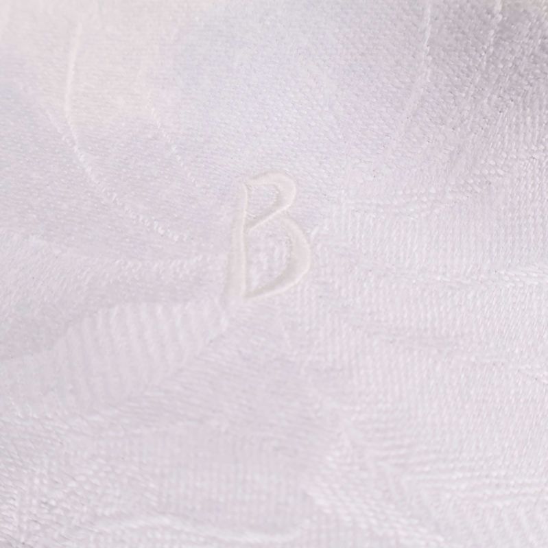 Närbild på monogram B i vit duk