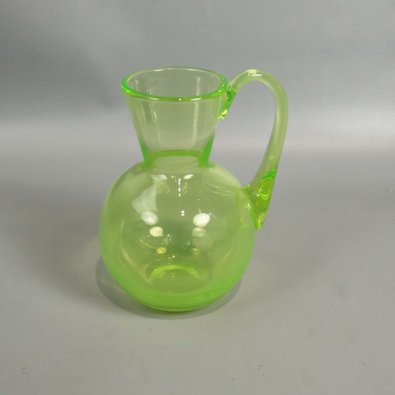 Grön kanna i glas med rund botten och handtag
