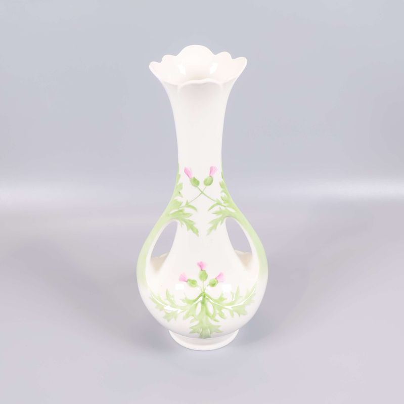 Vit vas med blomdekor och öppen design framifrån