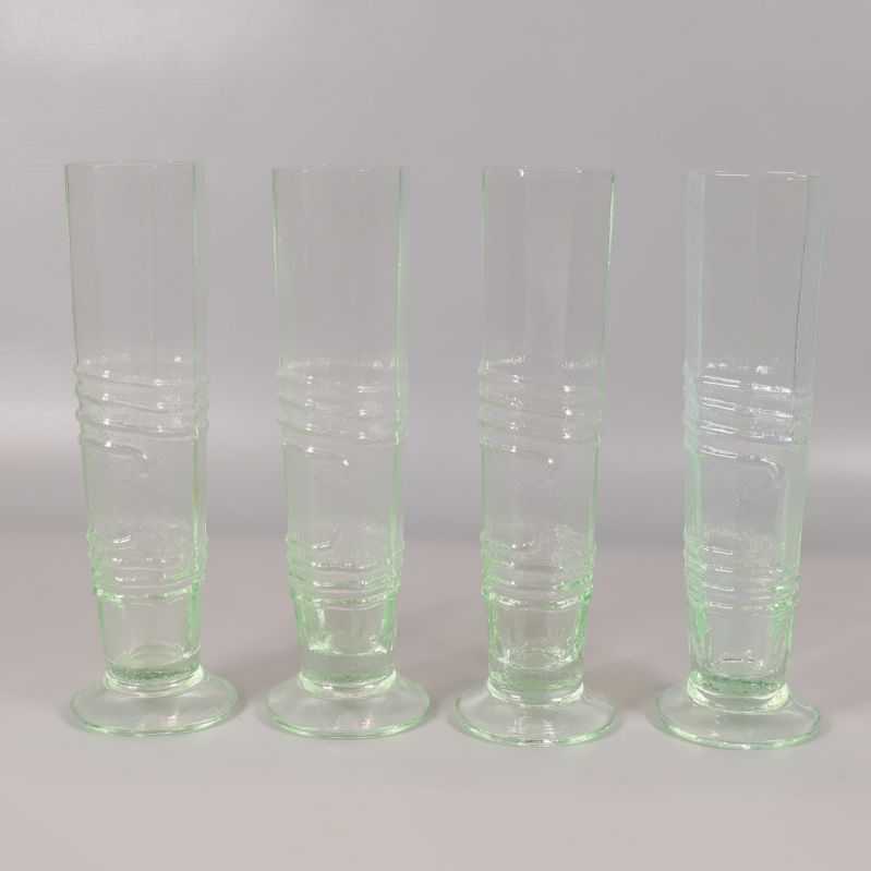 Fyra räfflade ljusgröna glas uppställda i rad