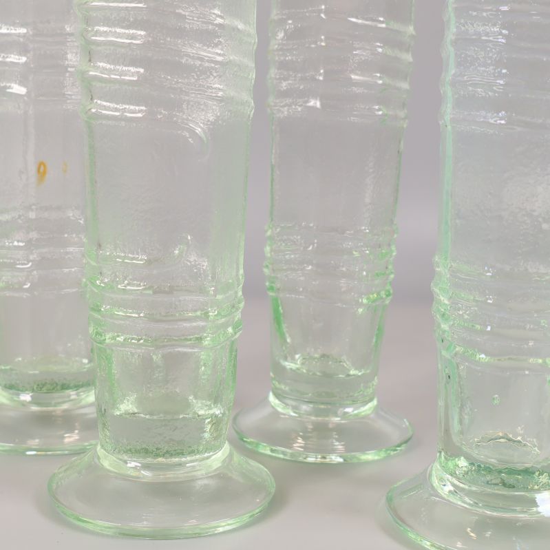 Närbild på fyra räfflade glas i ljusgrönt glas