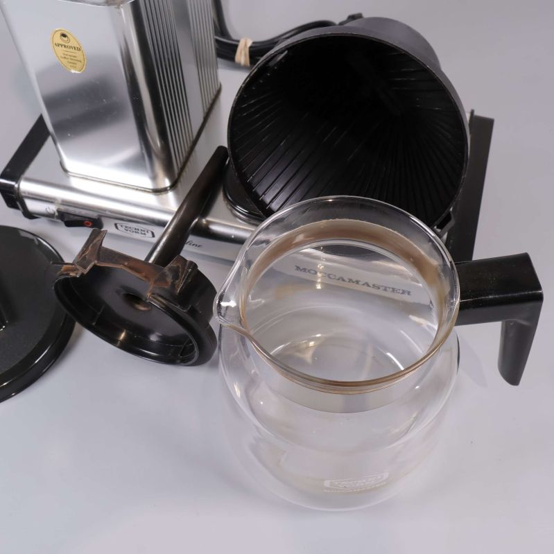 Närbild på glaskanna och filterhållare vid sidan av bryggaren
