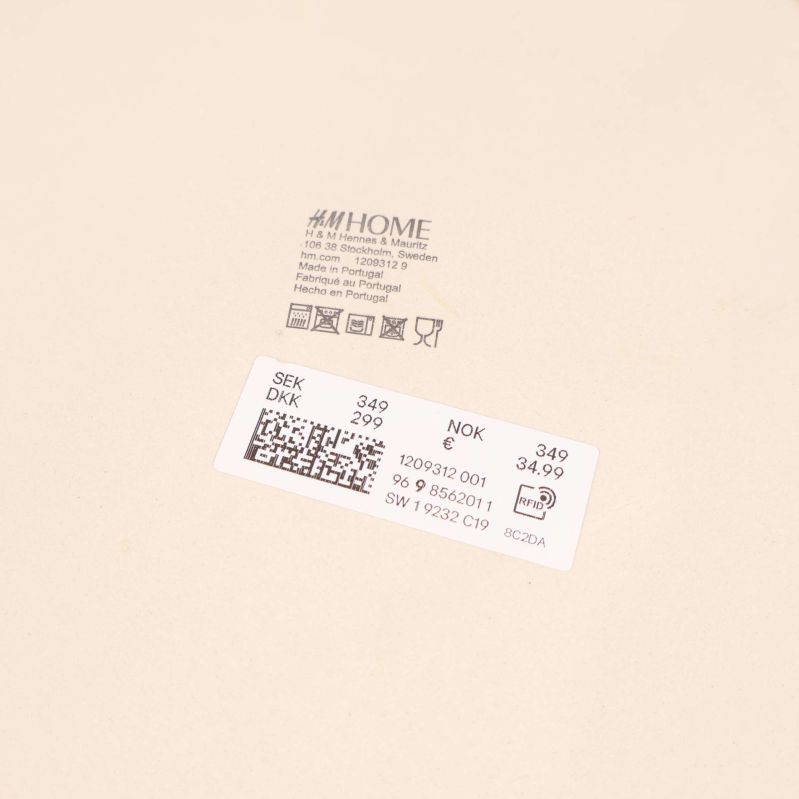 Närbild på etiketter och logotyp från H&M Home under skål