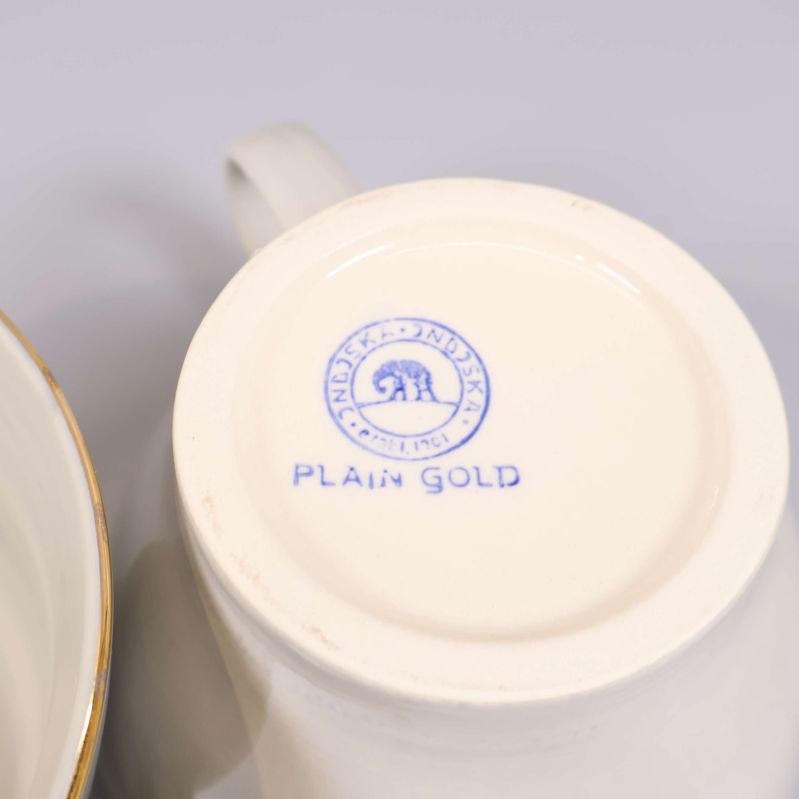 Närbild på botten av kopp med texten Plain Gold