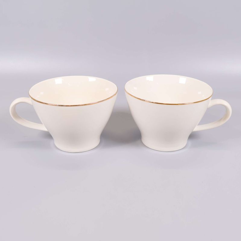 Två kaffekoppar i ljus färg med guldkant och handtag