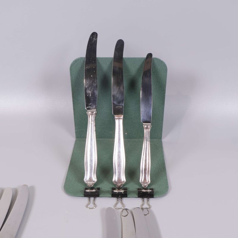 Tre knivar med dekorerade handtag på grön bakgrund