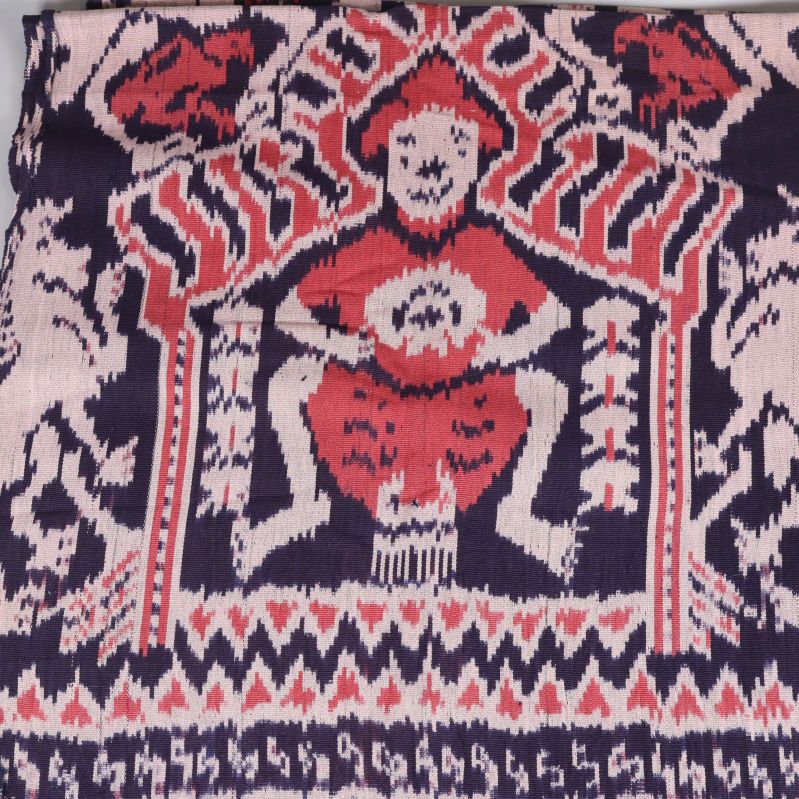 Närbild på plädens motiv i rött och lila
