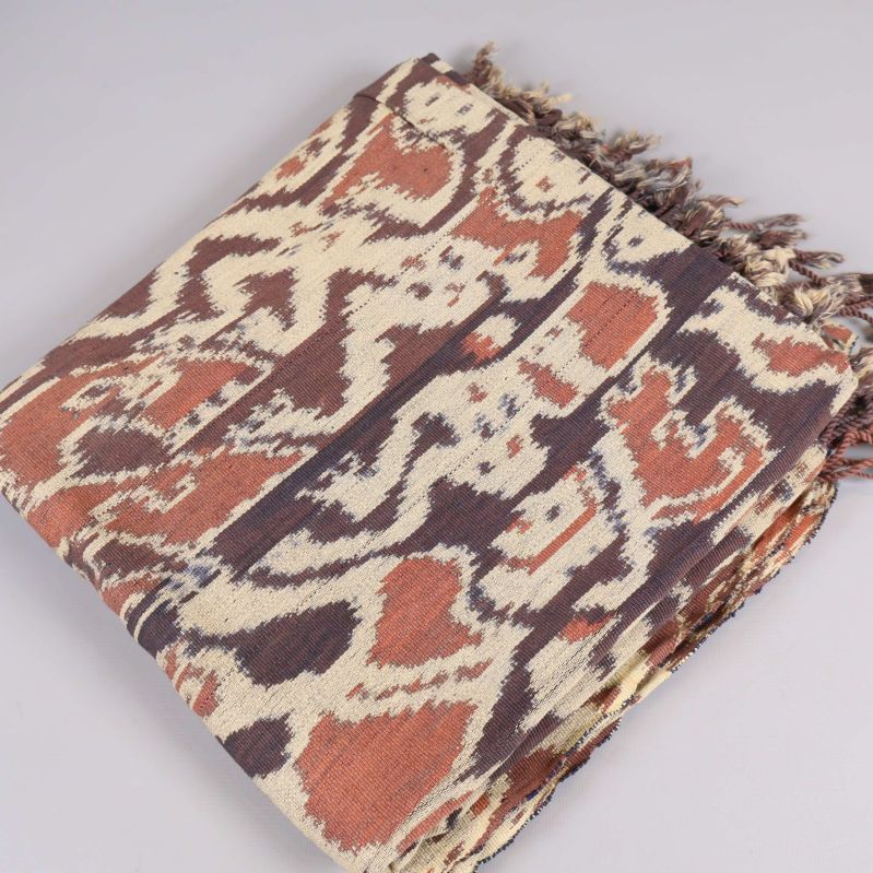 Vikta textilen med brunt och beige etnomönster och fransar