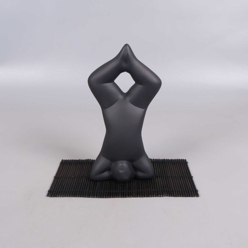 Yogafigur i huvudstående på svart matta