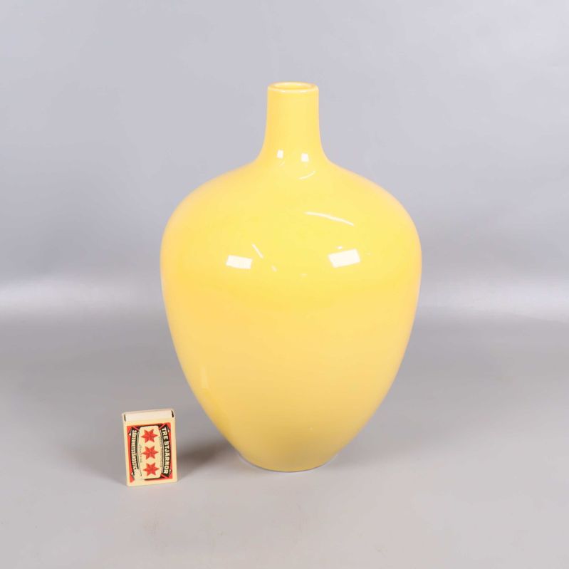 Gul vas bredvid tändsticksask för storleksjämförelse