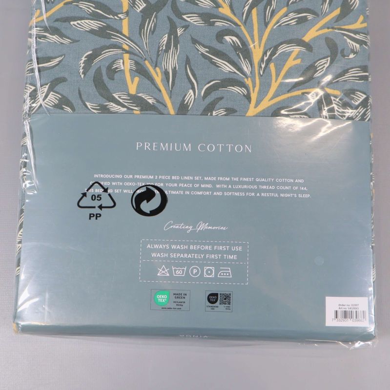Material- och tvättsymboler på baksidan av påslakansförpackningen