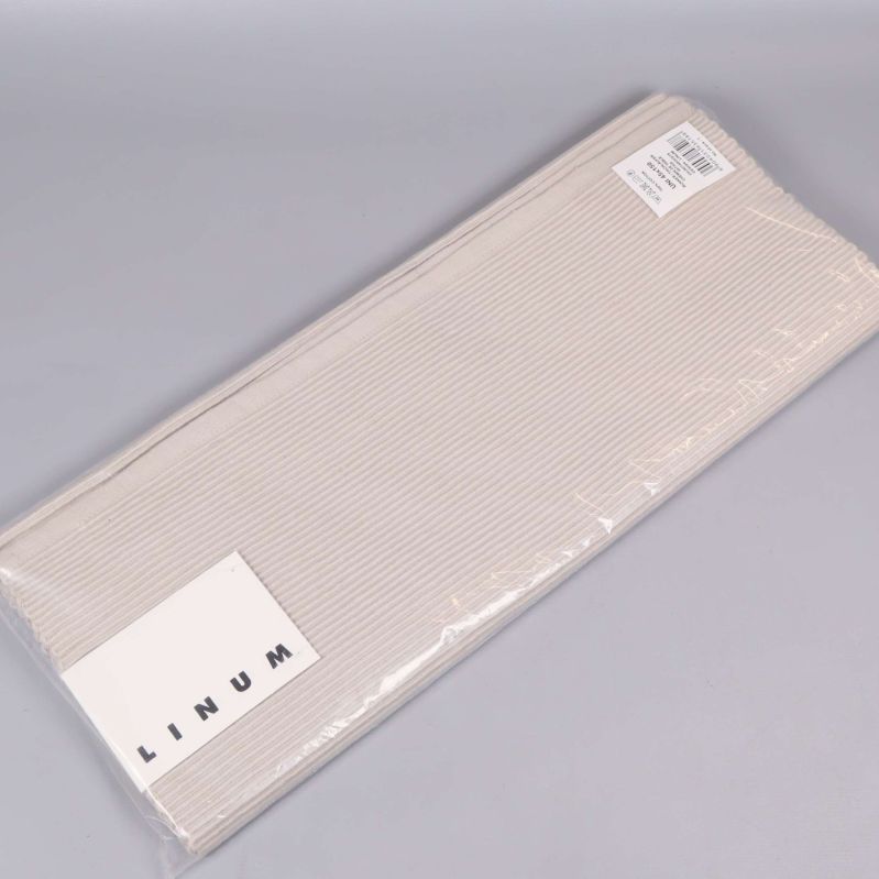 Beige bordslöpare i originalförpackning med etikett och linjemönster